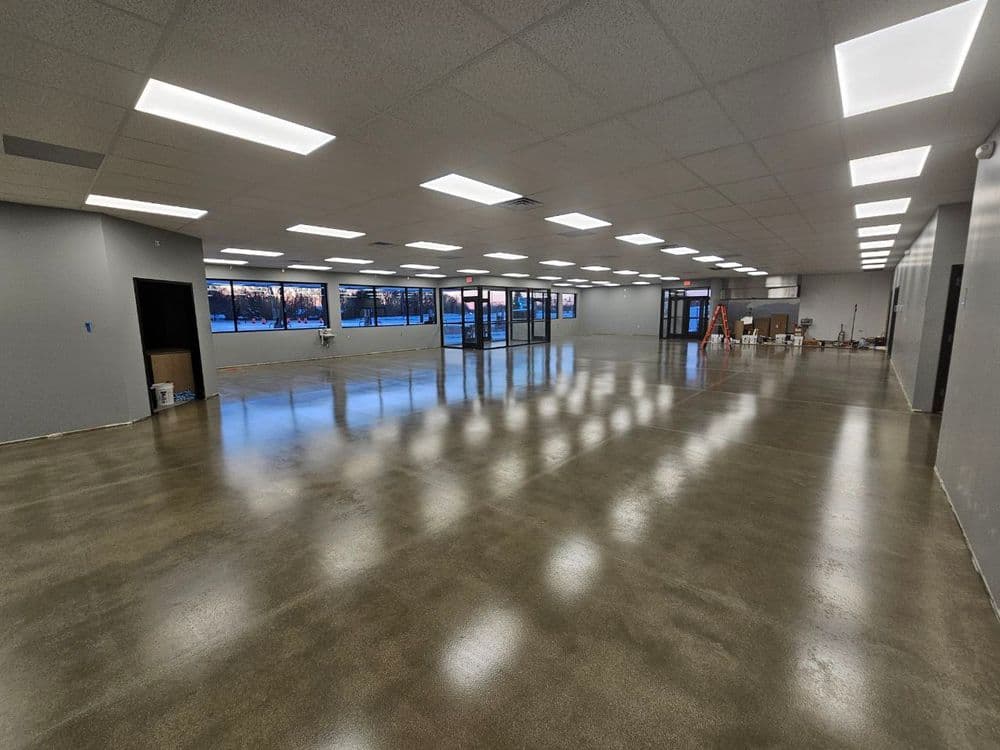 Empty commercial space with polished concrete flooring and large windows, ideal for retail or office use.
