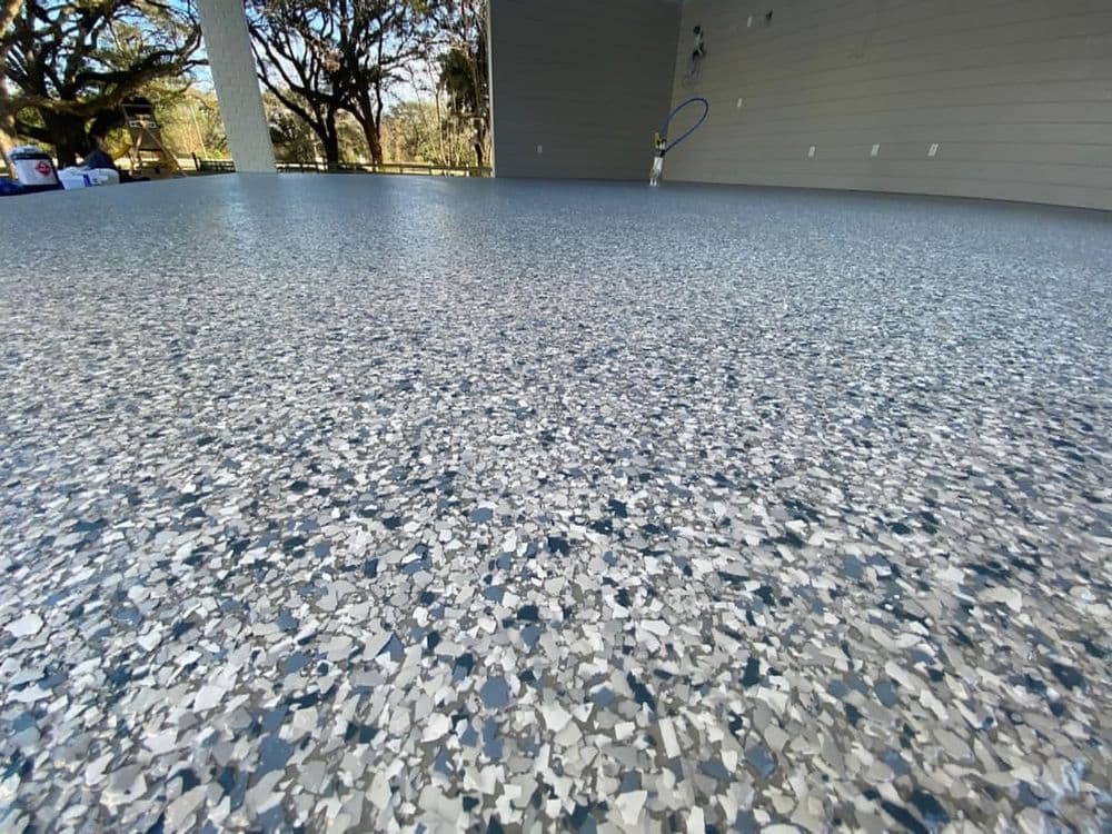 Epoxy flooring with a textured, blue and gray speckled design in a spacious area.