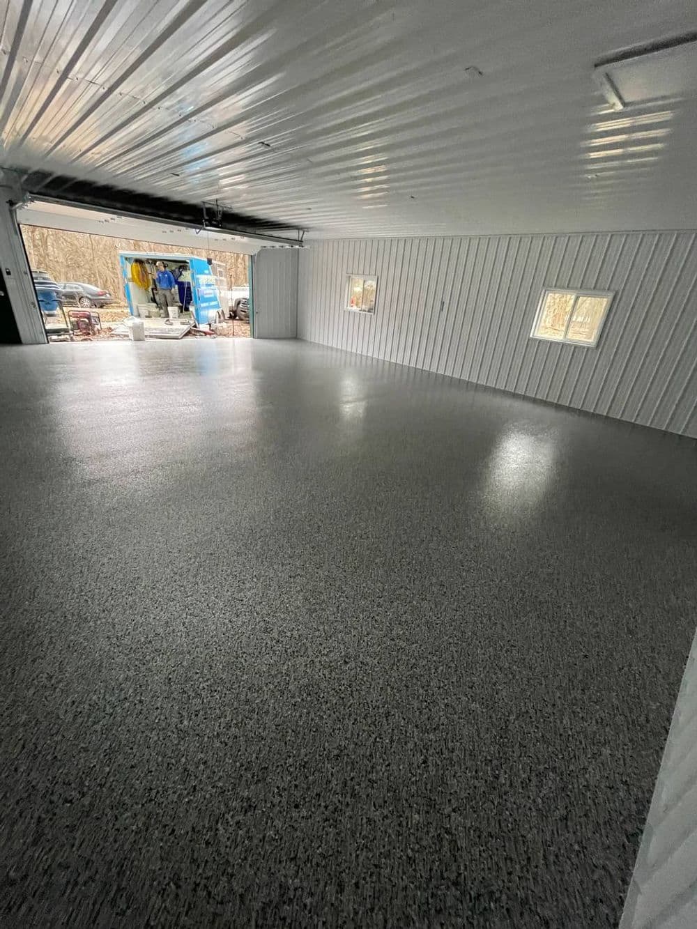 Interior of a spacious garage with a polished floor and natural light from windows.