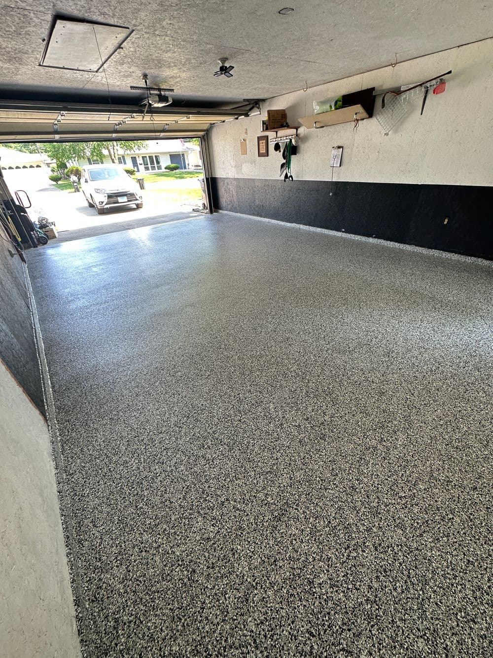 Newly finished garage floor with gray speckled coating, clean and organized space.