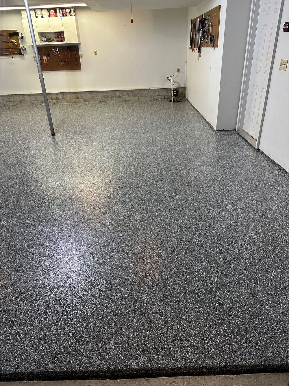 Newly finished gray epoxy garage floor with polished surface and clean surroundings.