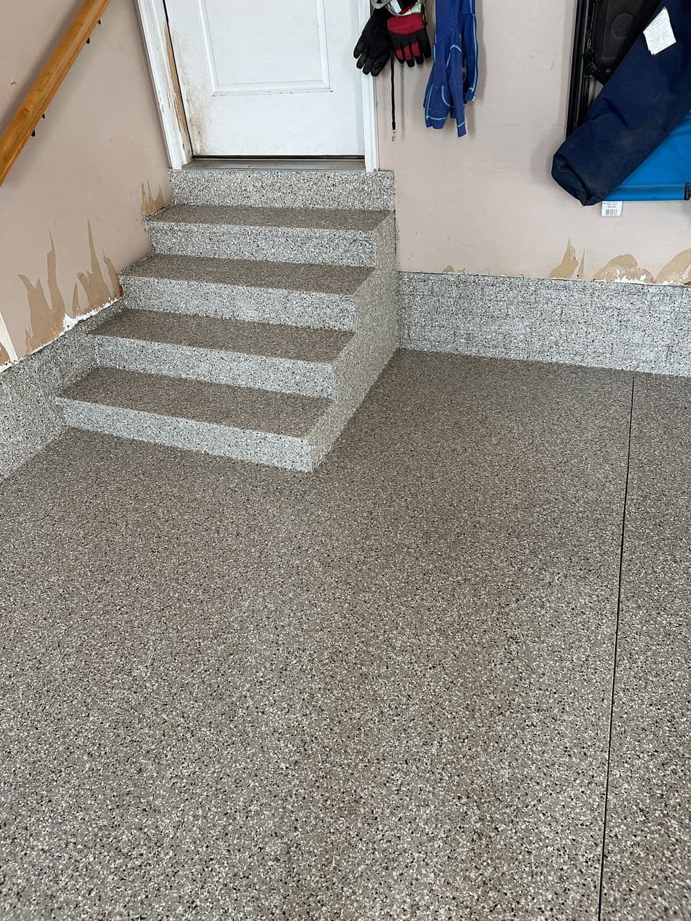 Renovated garage featuring decorative floor and steps with grey tones and clean finish.